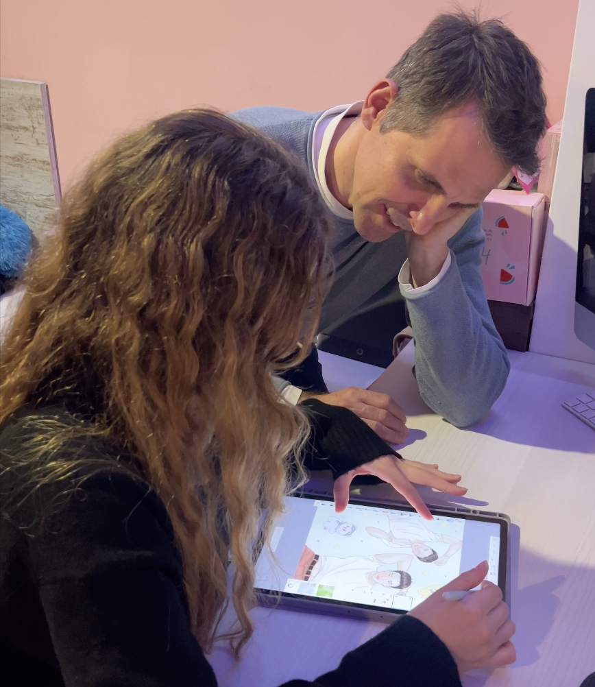 Karla dibujando en una tablet junto a su padre